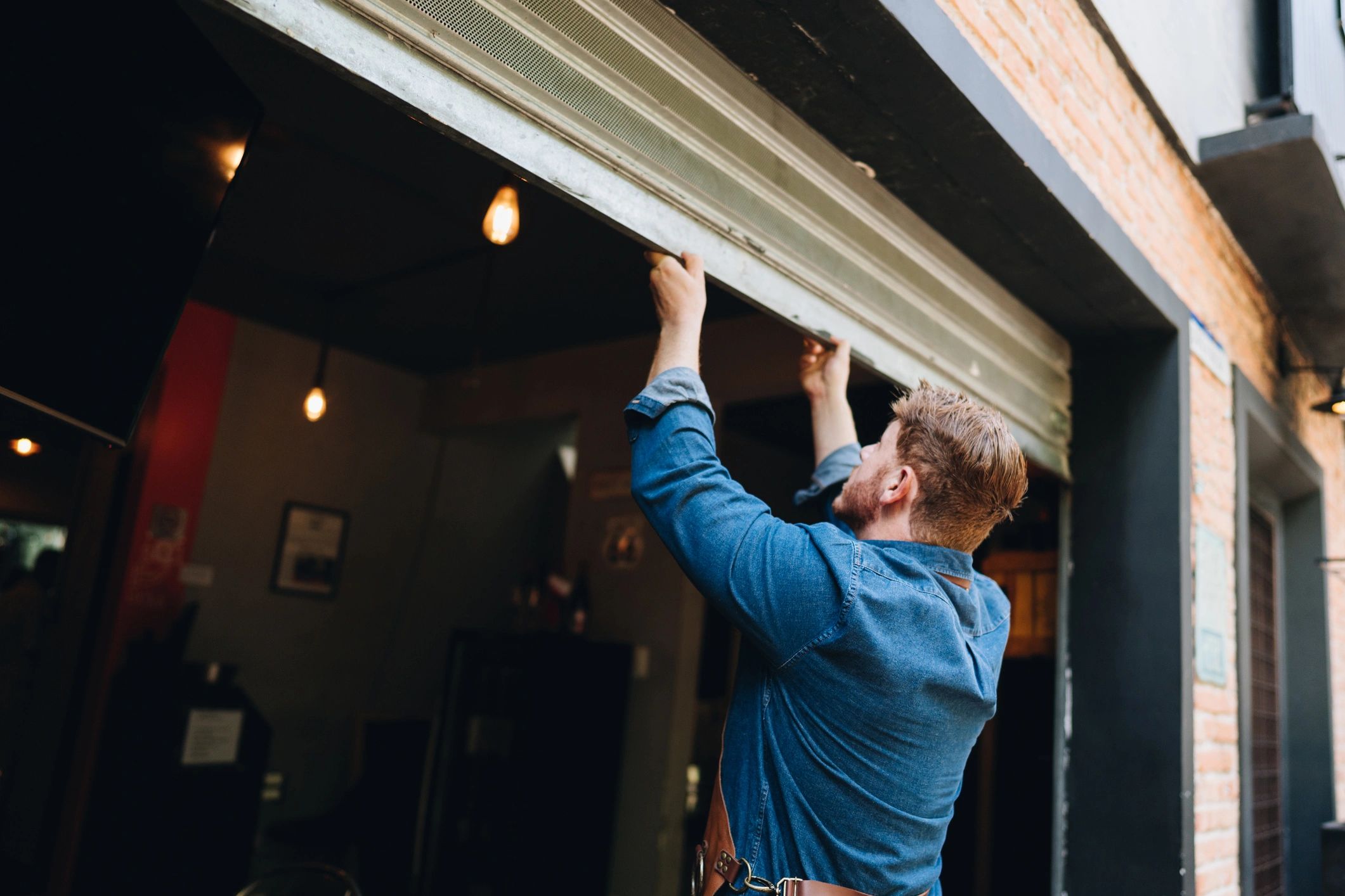 Technician working with a roll-up garage style shutter door